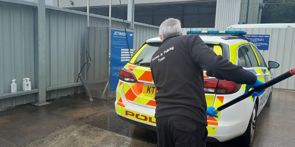 Showing the back of Steve as he checks a police car.