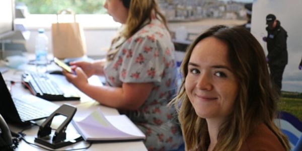 Smiling Police Staff member sat at desk