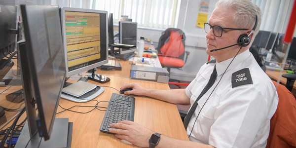 Call handler with headset looking at screen