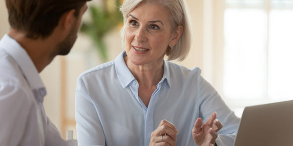 Middle aged women speaking with a younger male colleague