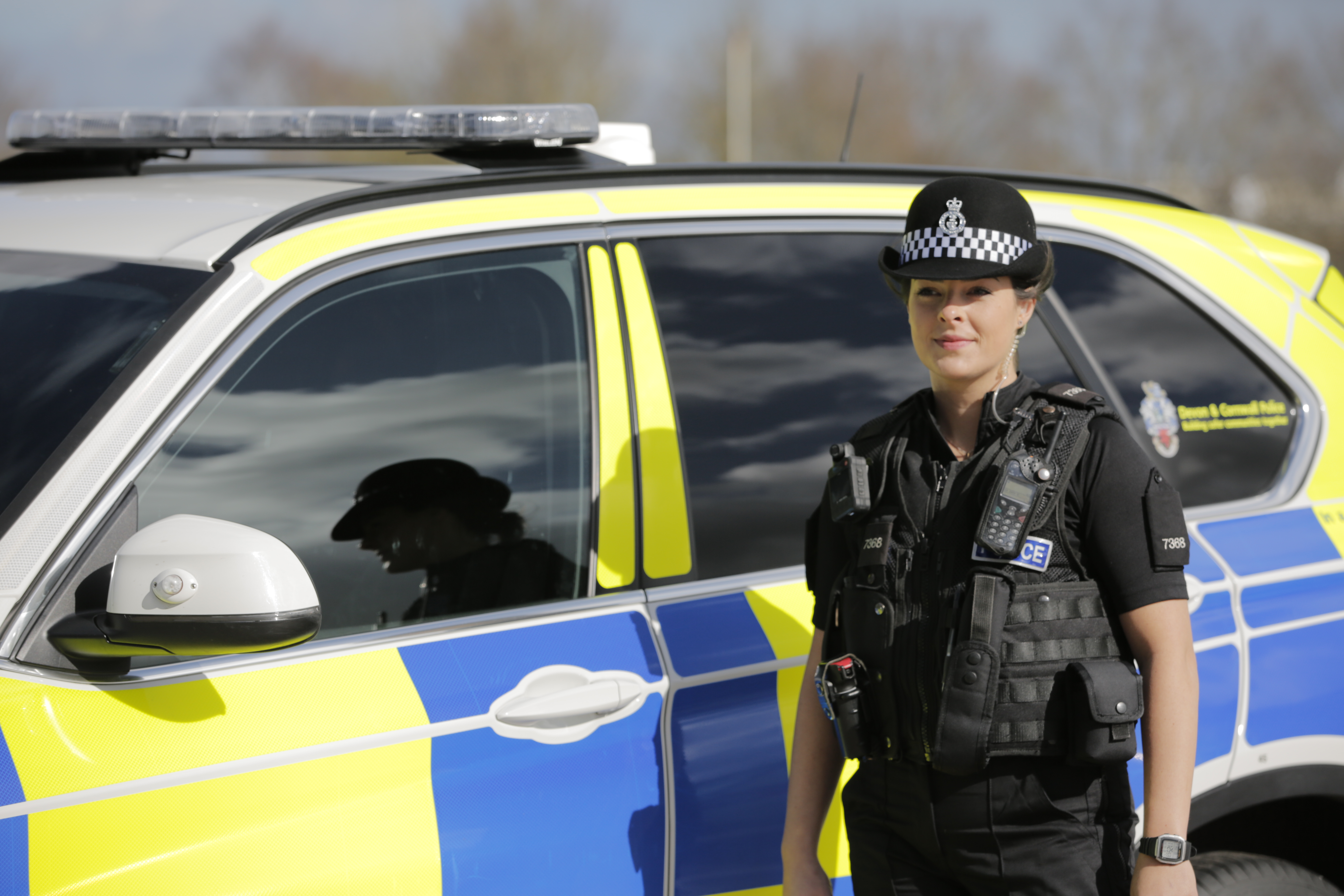 Female Police Officer next to a car