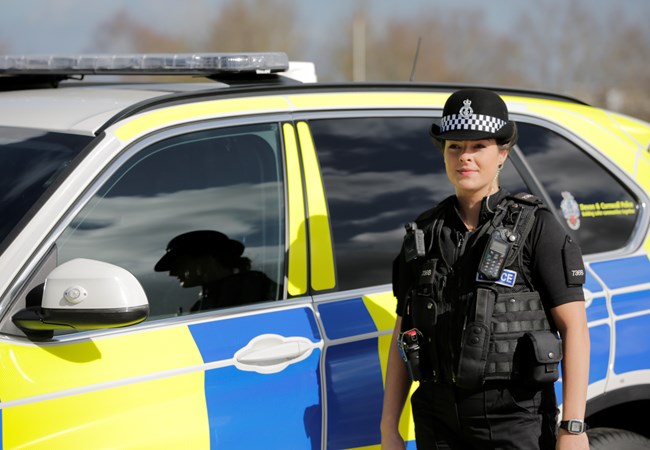 Female Police Officer next to a car